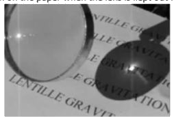 Shown below is a photograph of a convex lens.   A small, bright spot is seen on the paper when the lens is kept out facing the sun.      Which diagram below explains the formation of the bright spot?